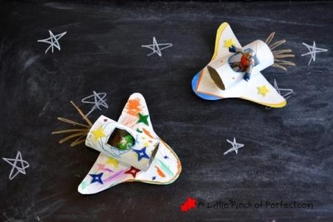 cardboard space shuttles on black background