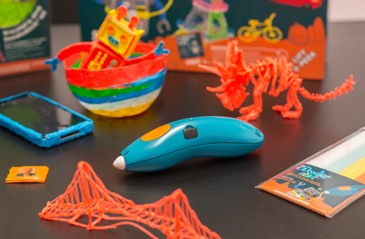 A 3D Doodle pen surrounded by several creations.